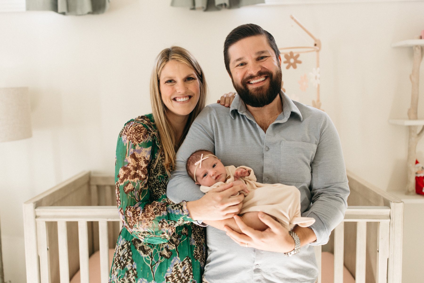 A young couple holding their newborn — one of the many families The Mill Financial Partners serves.